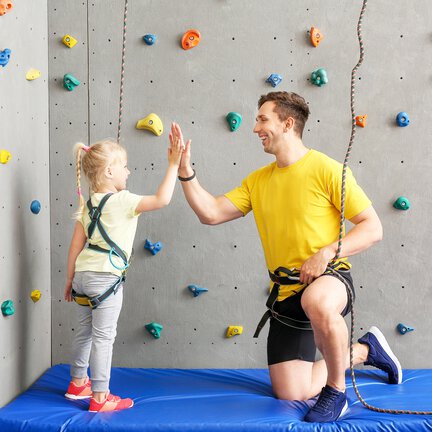 Climbing instructor with girl student at climbing centre.