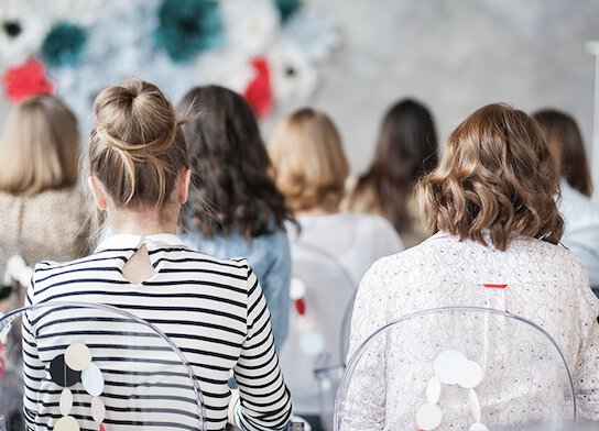 Female audience watching training presentation.